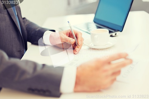 Image of man hands with contract and pen, coffee and laptop