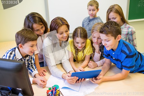 Image of group of kids with teacher and tablet pc at school