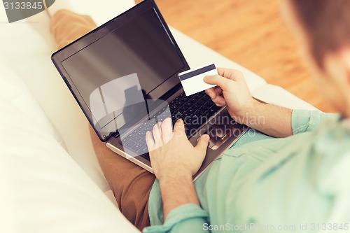 Image of close up of man with laptop and credit card
