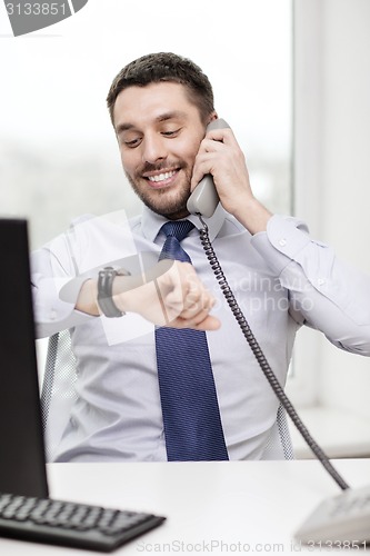 Image of smiling businessman making call