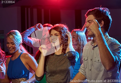 Image of group of happy friends dancing in night club