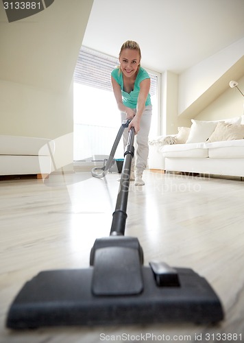 Image of happy woman with vacuum cleaner at home