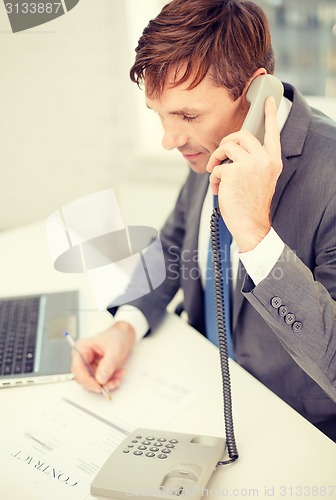 Image of businessman with laptop computer and phone