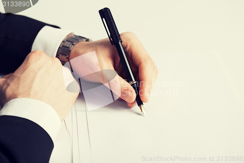 Image of businessman writing something on the paper