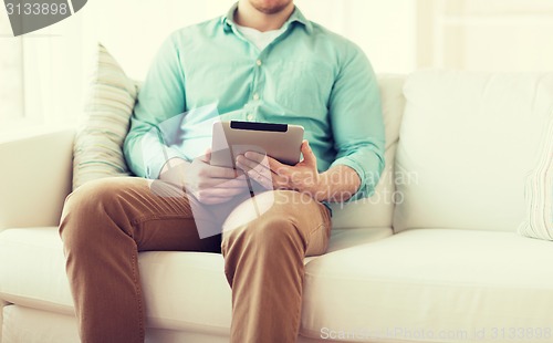 Image of close up of man with tablet pc computer at home