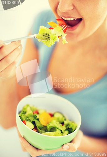 Image of woman eating salad with vegetables