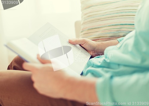 Image of close up of man reading book at home