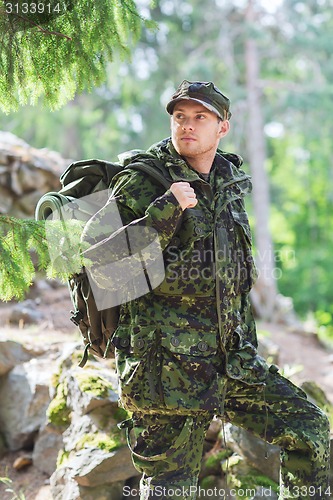 Image of young soldier with backpack in forest