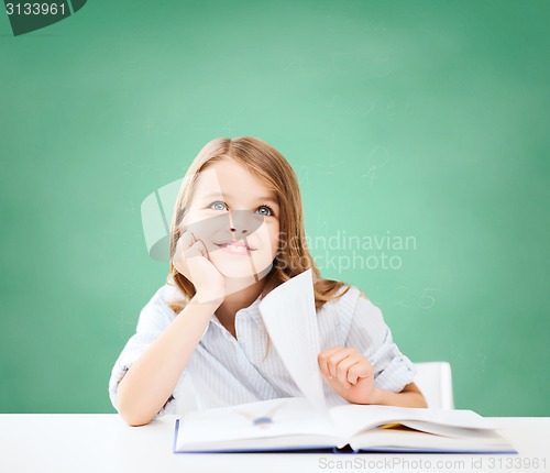 Image of happy student girl with book at school