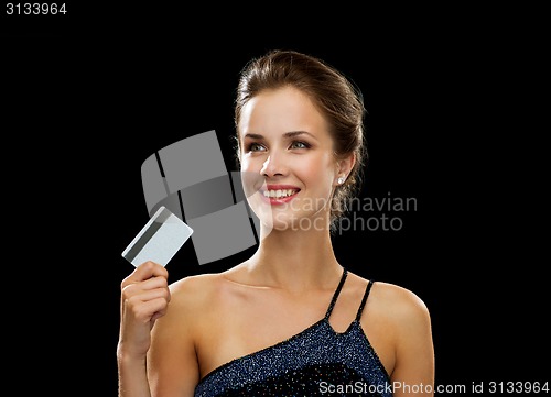 Image of smiling woman in evening dress holding credit card