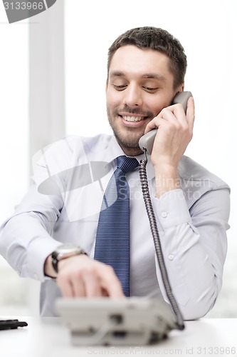 Image of smiling businessman with telephone dialing number