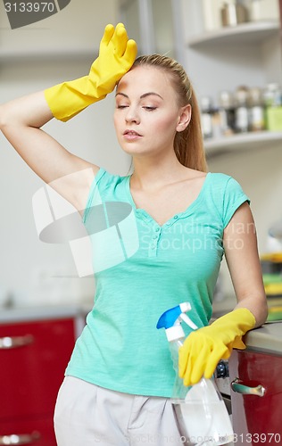 Image of tired woman cleaning home kitchen