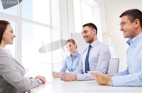 Image of group of smiling businesspeople meeting in office