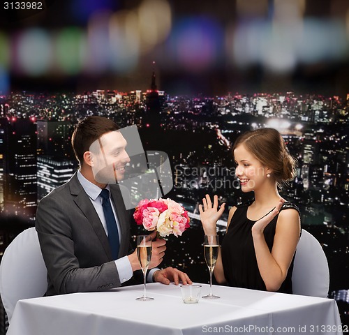 Image of smiling man giving flower bouquet to woman