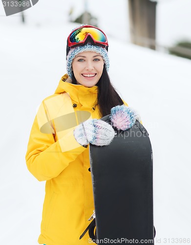 Image of happy young woman with snowboard outdoors