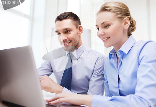 Image of smiling businesspeople with tablet pc in office
