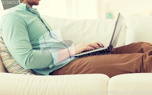 Image of close up of man working with laptop at home