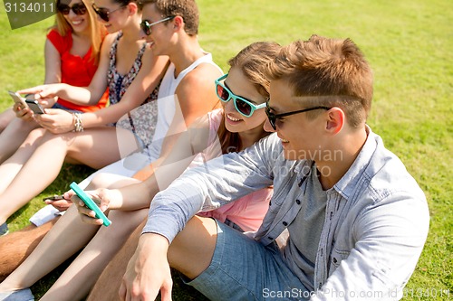 Image of smiling friends with smartphone making selfie