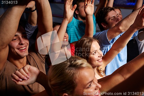 Image of group of smiling friends at concert in club