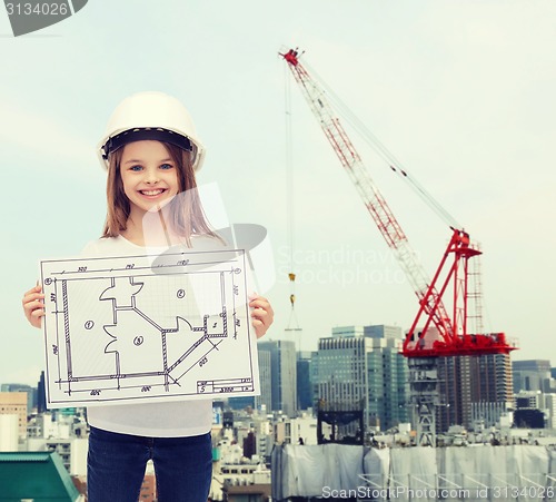 Image of smiling little girl in helmet showing blueprint