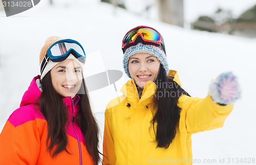 Image of happy girl friends in ski goggles outdoors