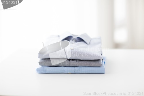 Image of close up of ironed and folded shirts on table