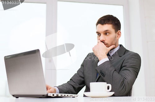 Image of businessman with laptop typing in office