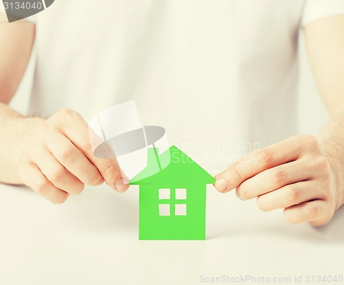 Image of hands holding green house