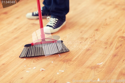 Image of close up of male brooming wooden floor