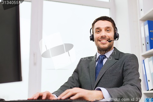 Image of smiling businessman with computer in office