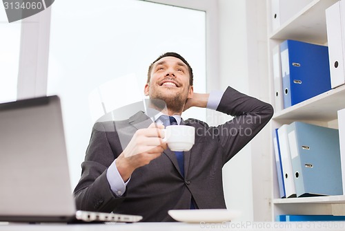 Image of businessman with laptop typing in office