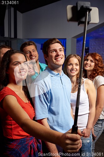 Image of friends with smartphone taking selfie in club