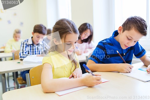 Image of group of school kids writing test in classroom