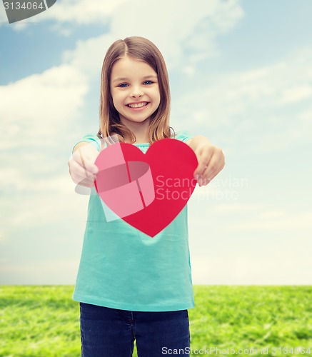 Image of smiling little girl giving red heart