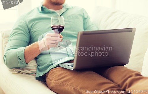 Image of close up of man with laptop and wine glass