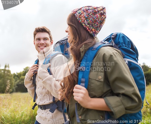 Image of smiling couple with backpacks hiking