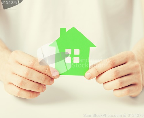 Image of hands holding green house