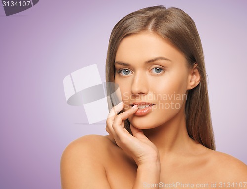 Image of beautiful young woman touching her lips