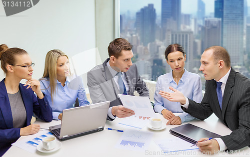 Image of business team with laptop and papers meeting