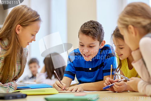 Image of group of students talking and writing at school