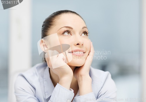 Image of smiling businesswoman dreaming in office