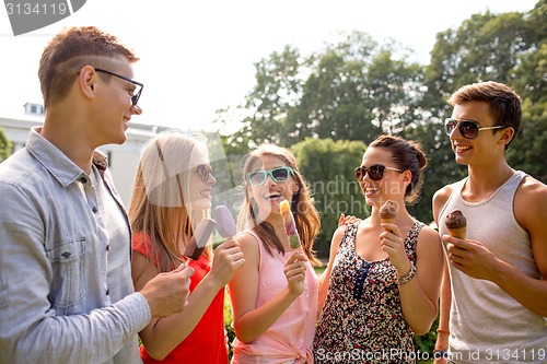 Image of group of smiling friends with ice cream outdoors