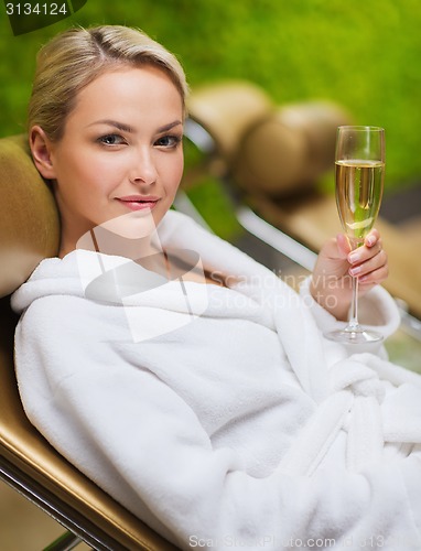 Image of beautiful young woman drinking champagne at spa