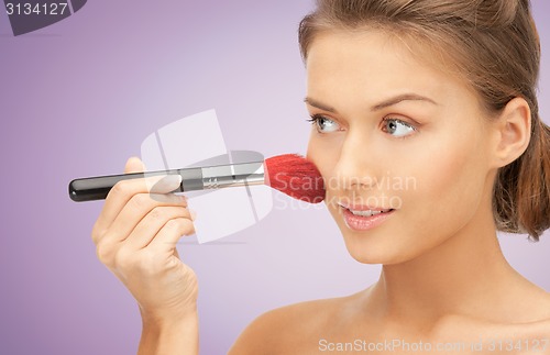 Image of close up of young woman with makeup brush