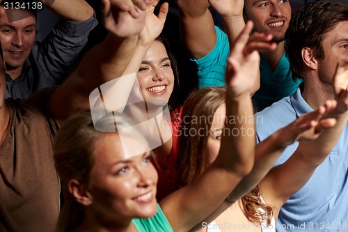 Image of smiling friends at concert in club