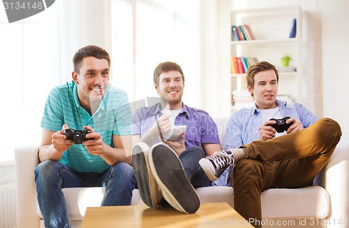 Image of smiling friends playing video games at home