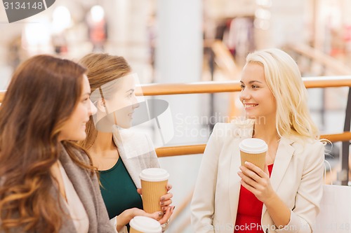 Image of young women with shopping bags and coffee in mall