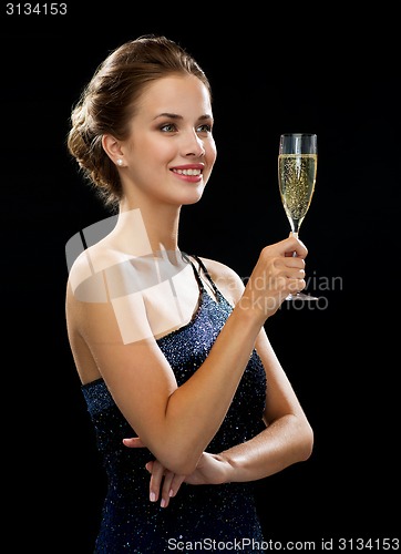 Image of smiling woman holding glass of sparkling wine