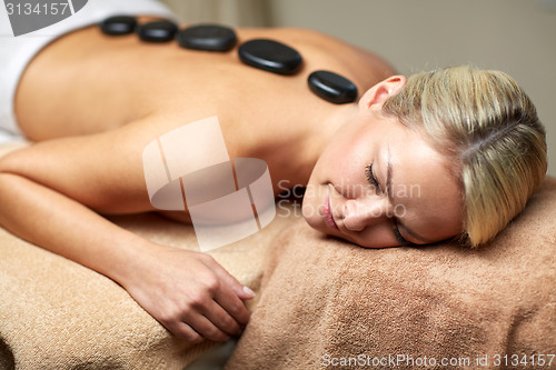 Image of close up of woman having hot stone massage in spa