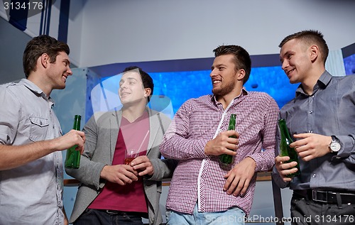 Image of group of male friends with beer in nightclub